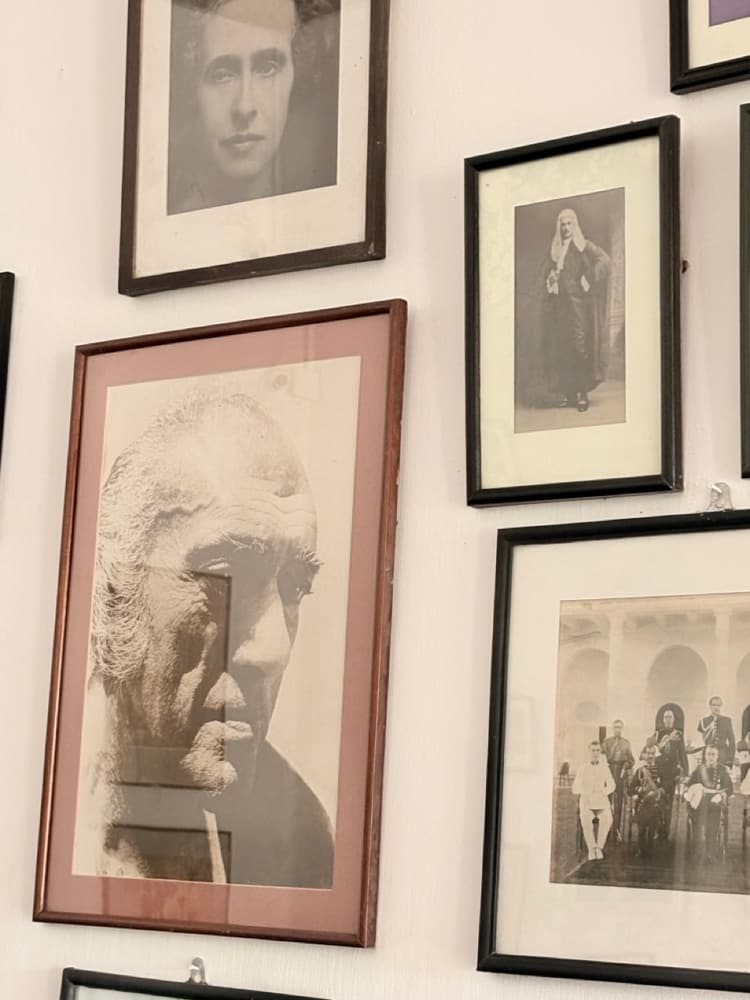 Wall of framed black and white family portraits and photographs inside the house