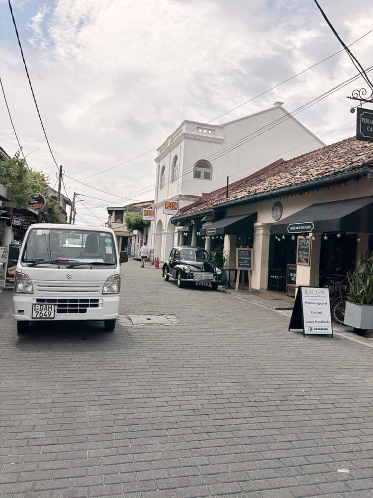 Pedlar Street inside Galle Fort with a vintage black car parked outside Pedlar's Inn Café and colonial shopfronts