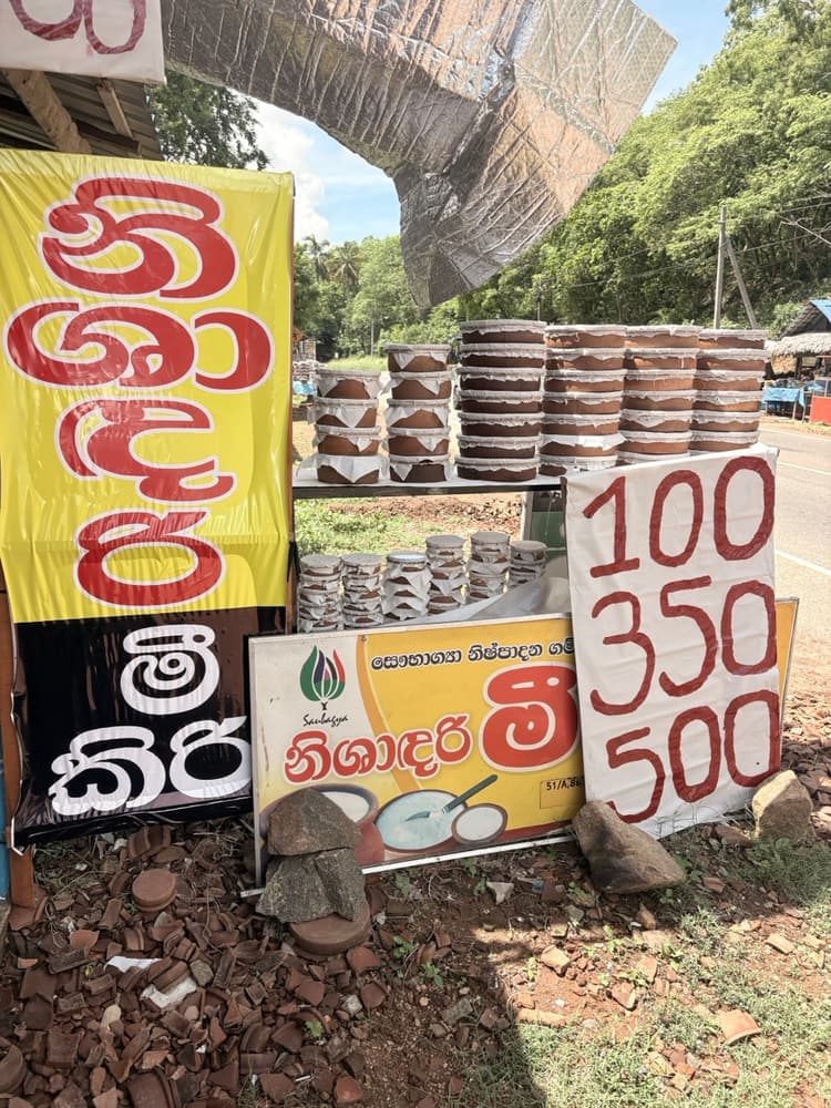 Clay pots of buffalo curd stacked at a roadside stall near Kantale, priced 100, 350 and 500 rupees