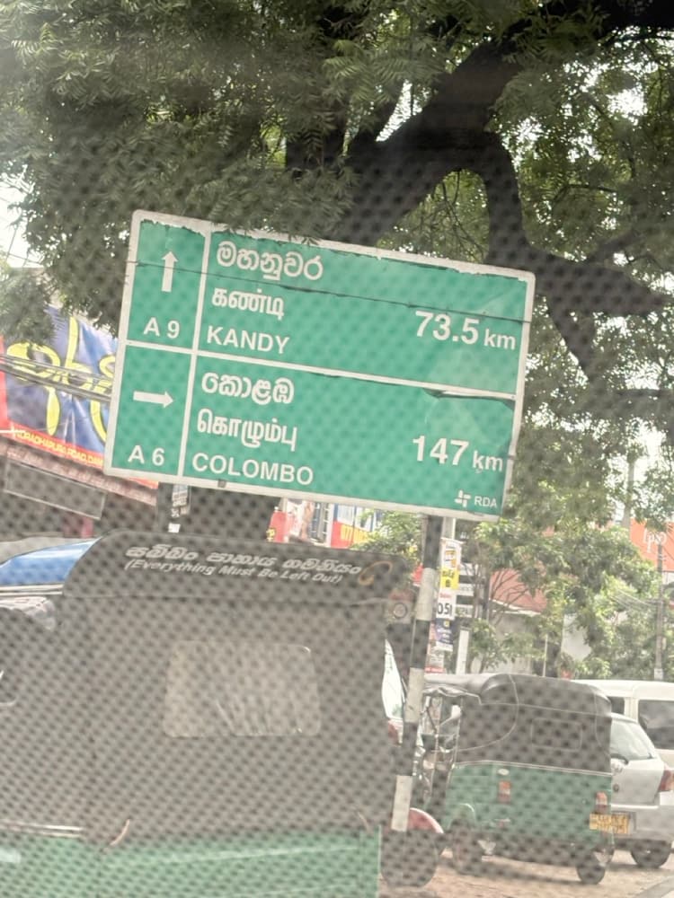 Green road sign at Dambulla pointing to Kandy 73.5 km on the A9 and Colombo 147 km on the A6