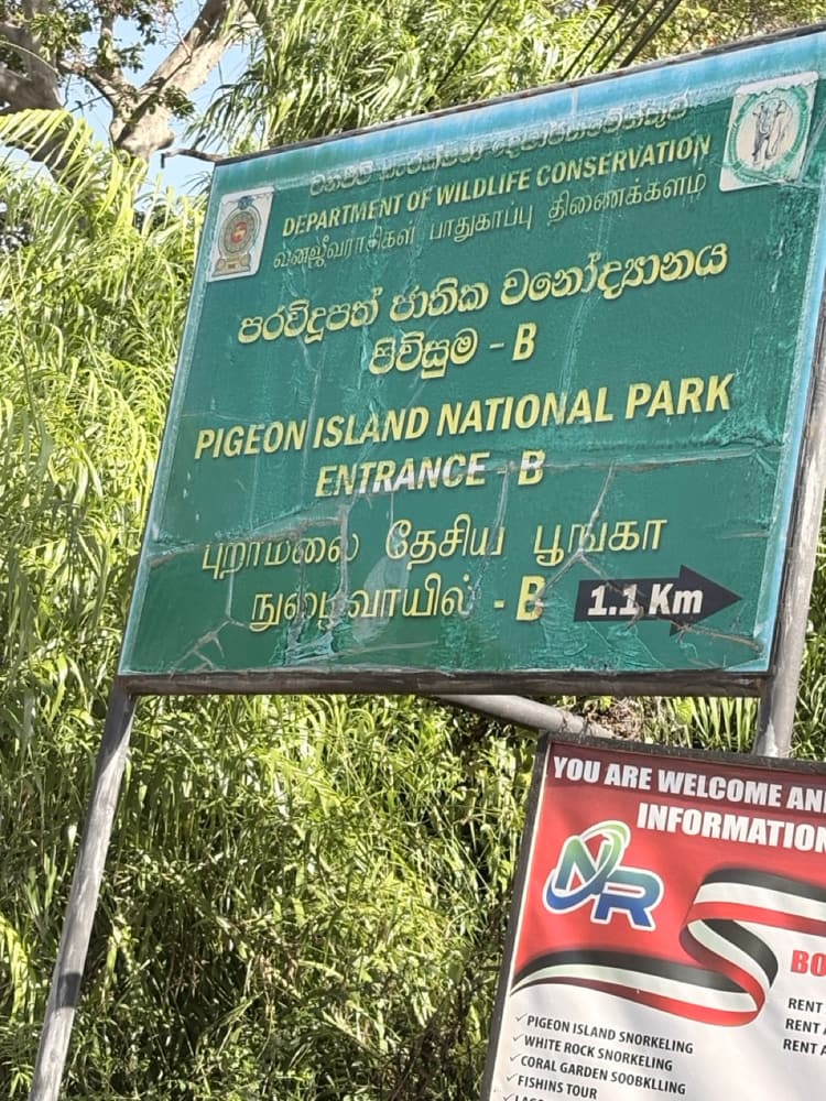 Department of Wildlife Conservation sign for Pigeon Island National Park Entrance B, 1.1 km, at Nilaveli