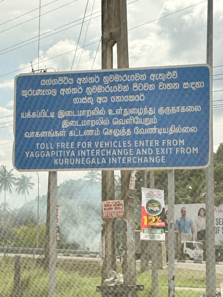 Blue road sign saying vehicles entering at Yaggapitiya interchange and leaving at Kurunegala interchange pay no toll