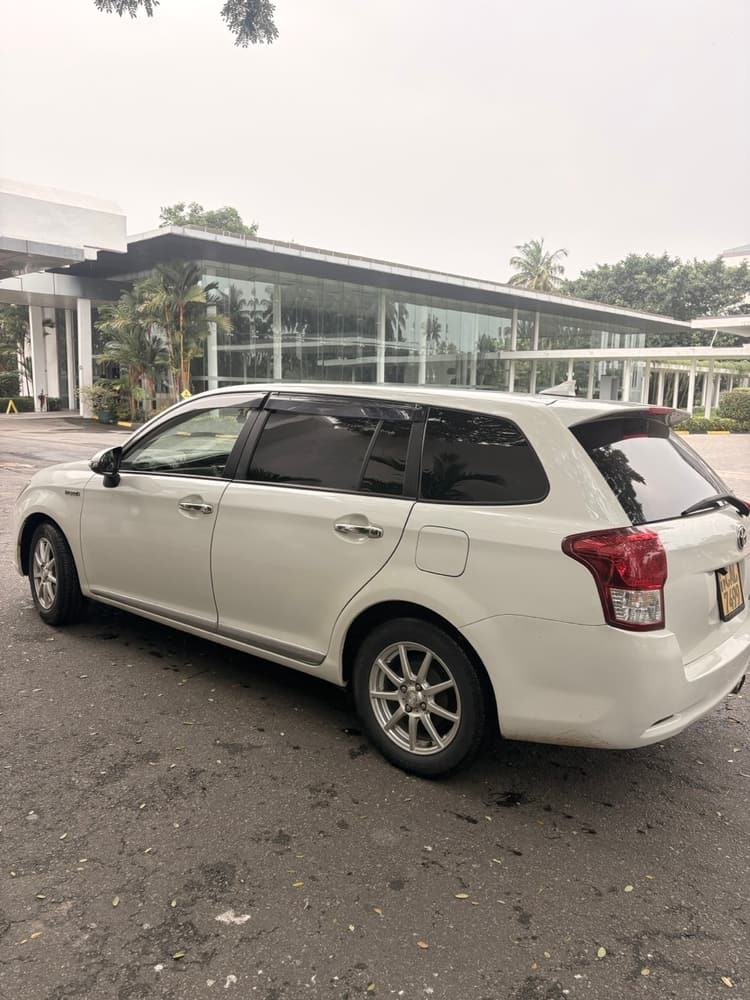 White TaxiGo car parked outside the glass lobby of Vivanta Colombo Airport Garden