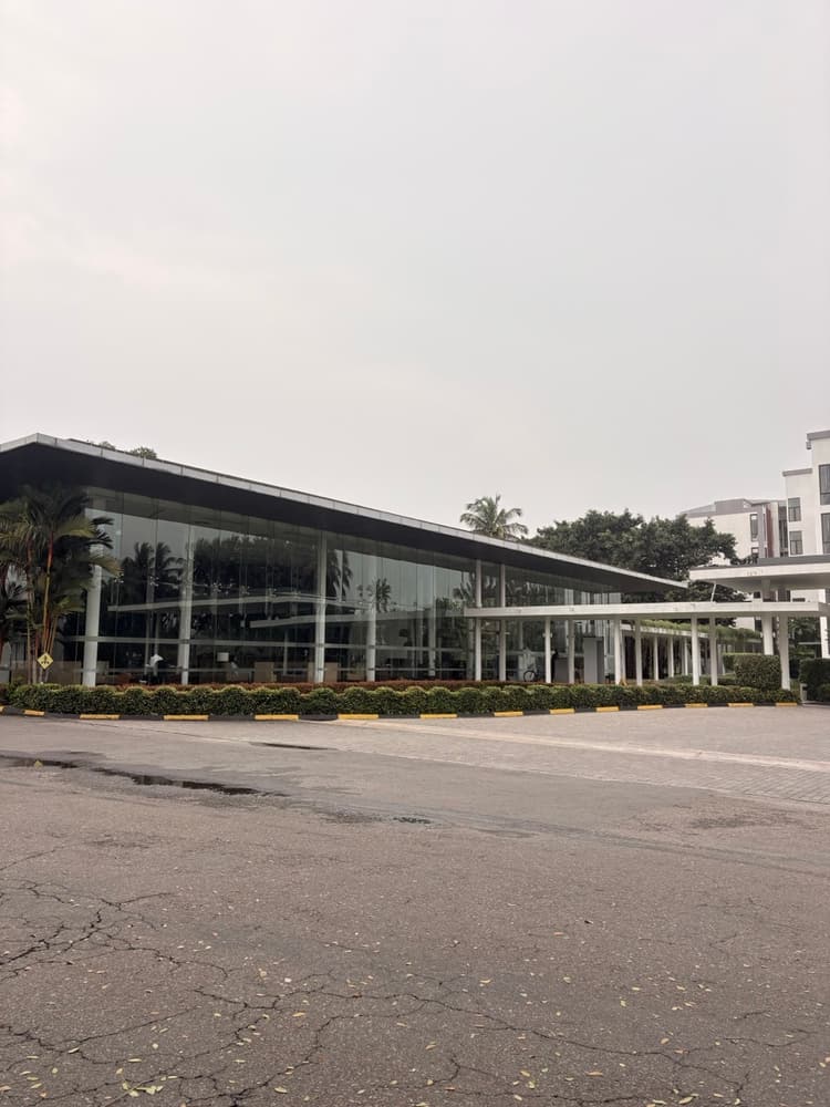 Long glass-walled lobby pavilion with a flat overhanging roof at Vivanta Colombo Airport Garden