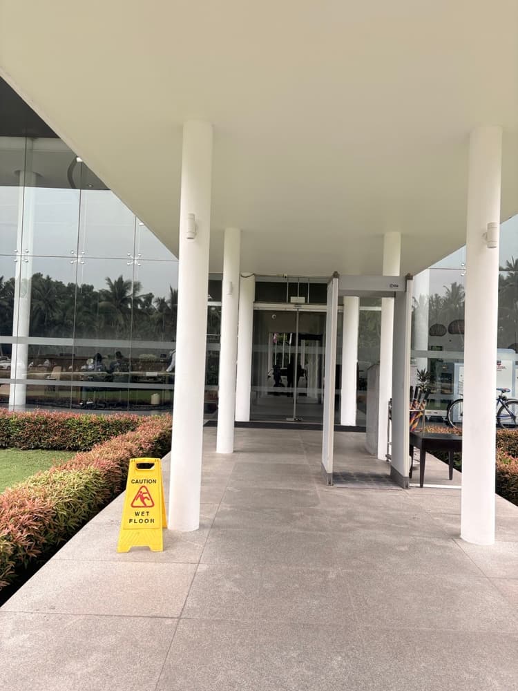 Covered walkway with white columns leading to the glass doors of the hotel lobby